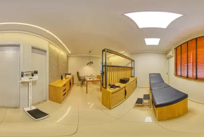 Consultório de Sorocaba: sala ampla com balança, mesa de madeira clara, maca e persianas